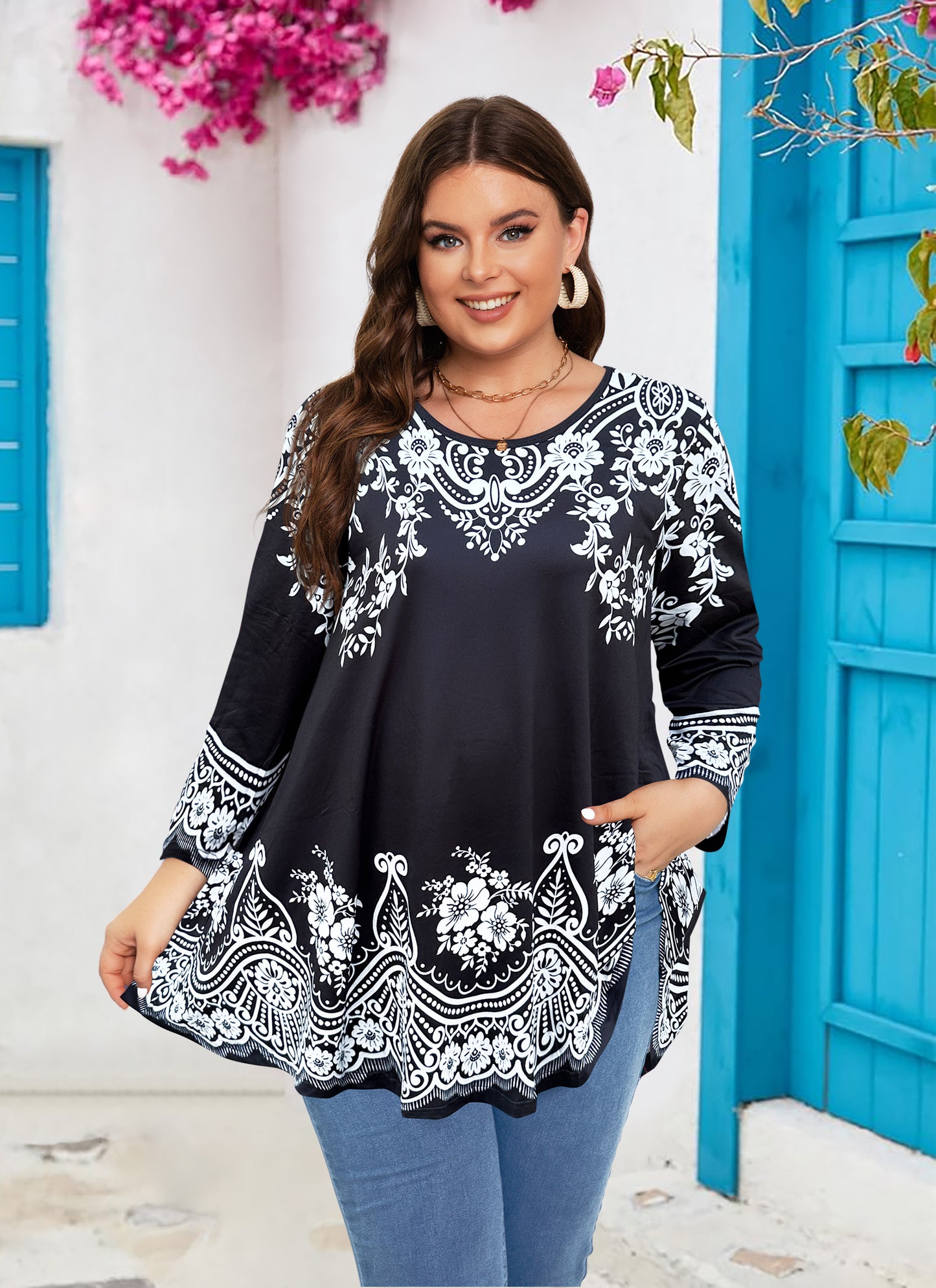 Woman wearing a black floral embroidered top in front of a blue door.