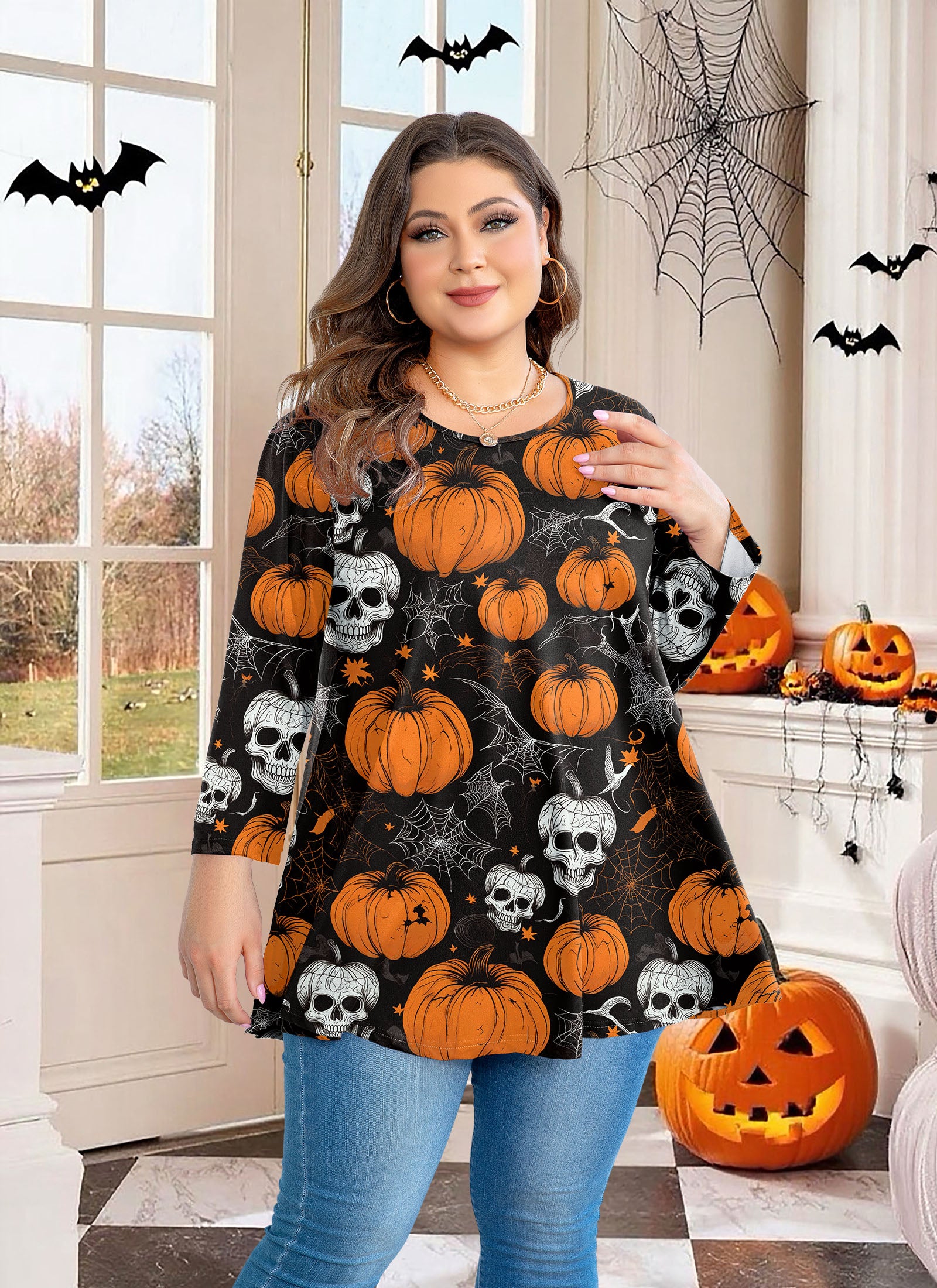 Woman wearing a Halloween-themed dress with pumpkins and skulls in a decorated room.